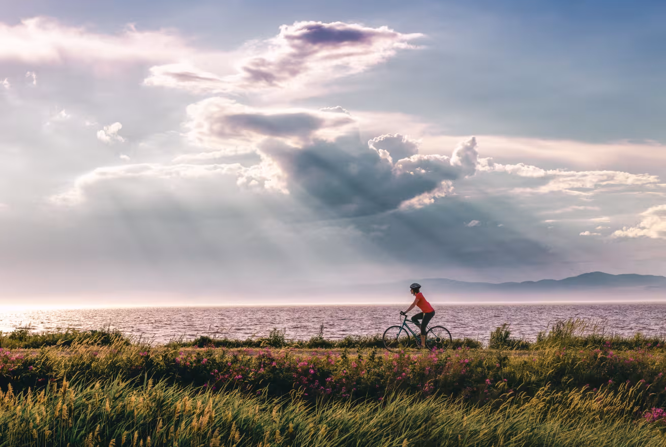 Un cycliste roule au bord du fleuve Saint-Laurent sur le circuit des Églantiers dans la région du Bas-Saint-Laurent