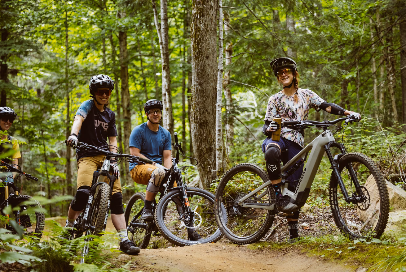 Trois cyclistes en vélo de montagne prennent une pause sur un sentier