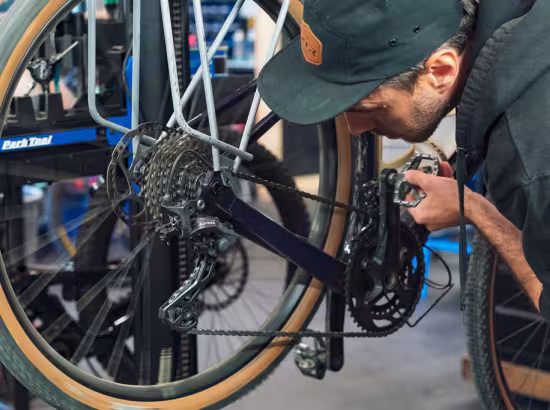 Un mécanicien vélo ajuste le dérailleur arrière d'un vélo
