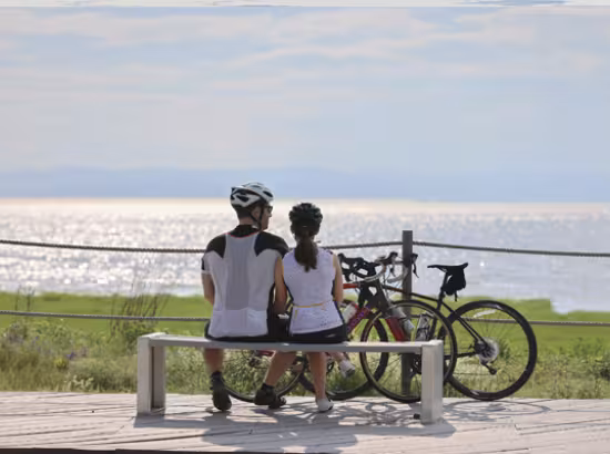 Deux cyclistes contemplement le fleuve Saint-Laurent au Québec