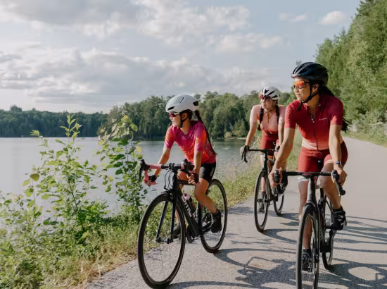 Trois cyclistes de route font du vélo le long d'un lac en Outaouais