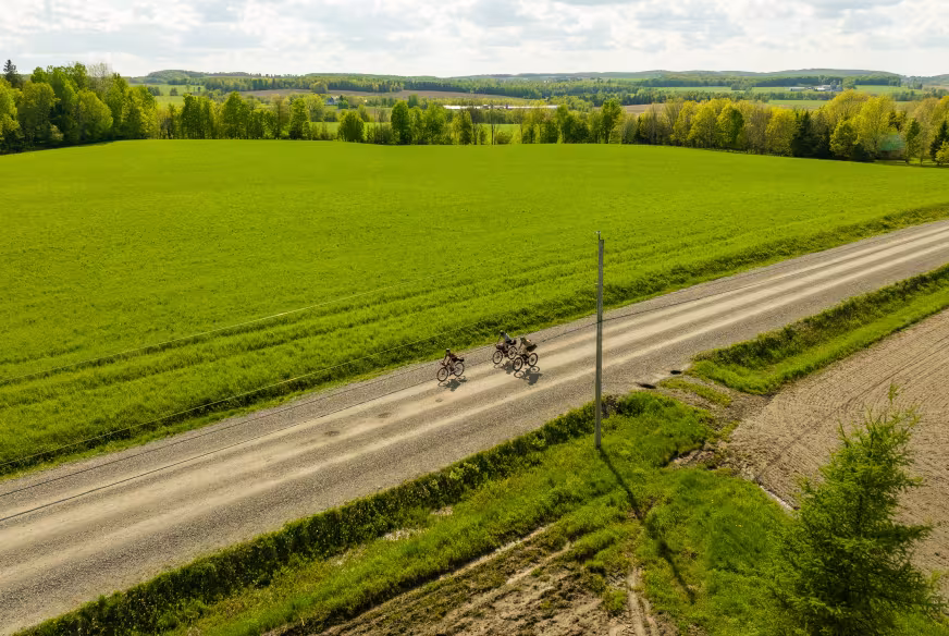 Trois cyclistes de vélo d'aventure roulent sur une route de gravelle dans les Cantons-de-l'Est