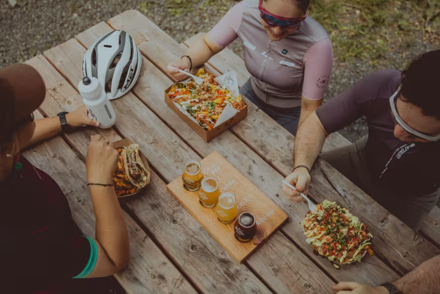 Des cyclistes sont attablés et prennent une collation