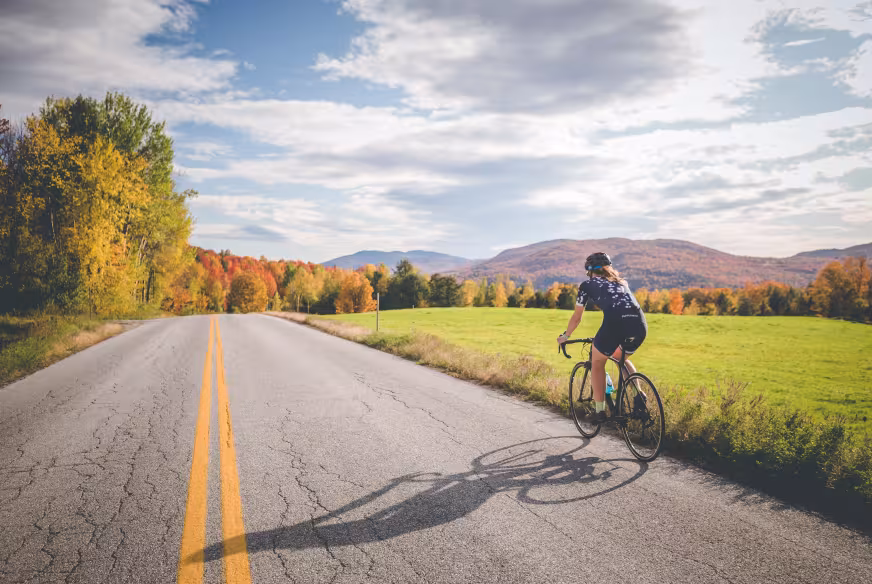 Une personne à vélo roule sur une route de campagne dans les Cantons-de-l'Est