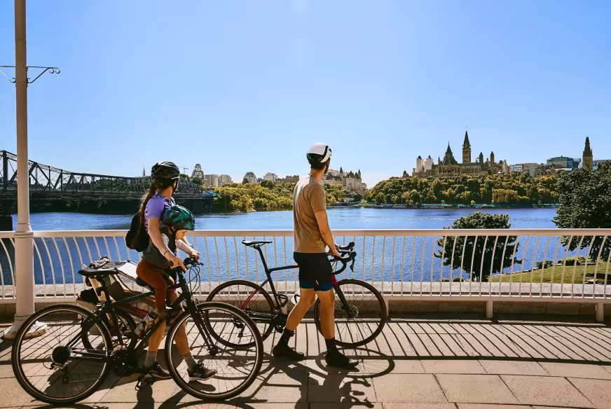 Une famille de cyclistes marchent avec leur vélo devant le Musée Canadien de l'Histoire à Gatineau en Outaouais